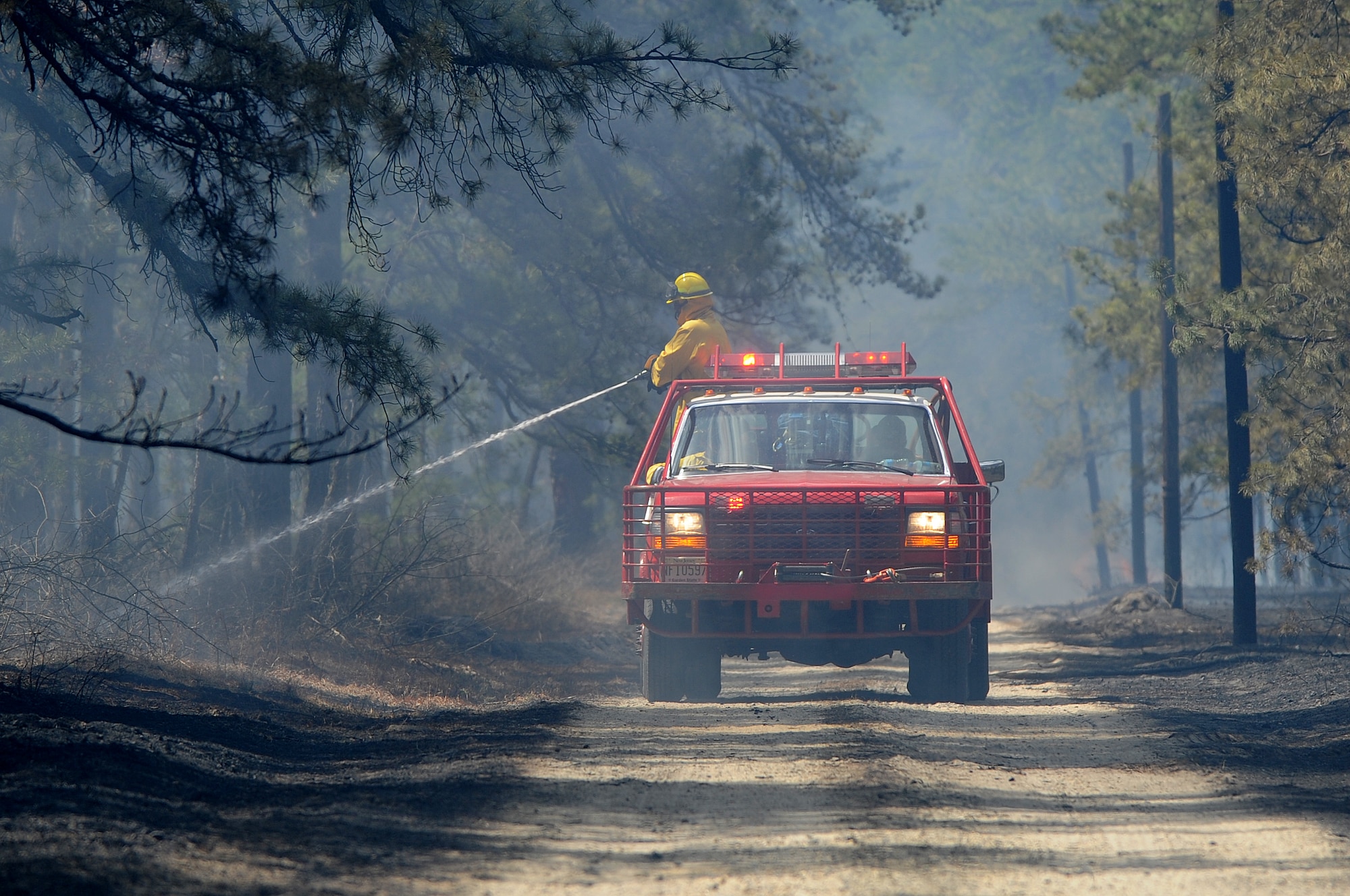 A New Egypt brush truck douses burned underbrush at the training ranges on Joint Base McGuire-Dix-Lakehurst April 9. No injuries or structural damages were reported from the fire. (U.S. Air Force photo by Russ Meseroll/Released)