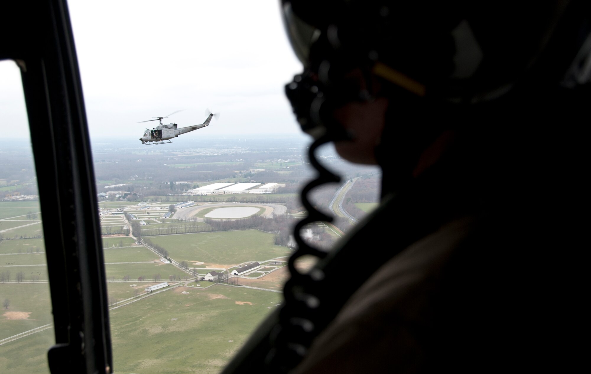 Lance Cpl. Ryan Jackson, crew chief assigned to Marine Helicopter Light Attack 773, observes a UH-1N Iroquois during flight March 21. As a crew chief, Jackson is not only responsible for maintaining the aircraft, but he also assist the pilot and co-pilot with airborne navigation. (U.S. Air Force photo by Staff Sgt. David Carbajal/Released)