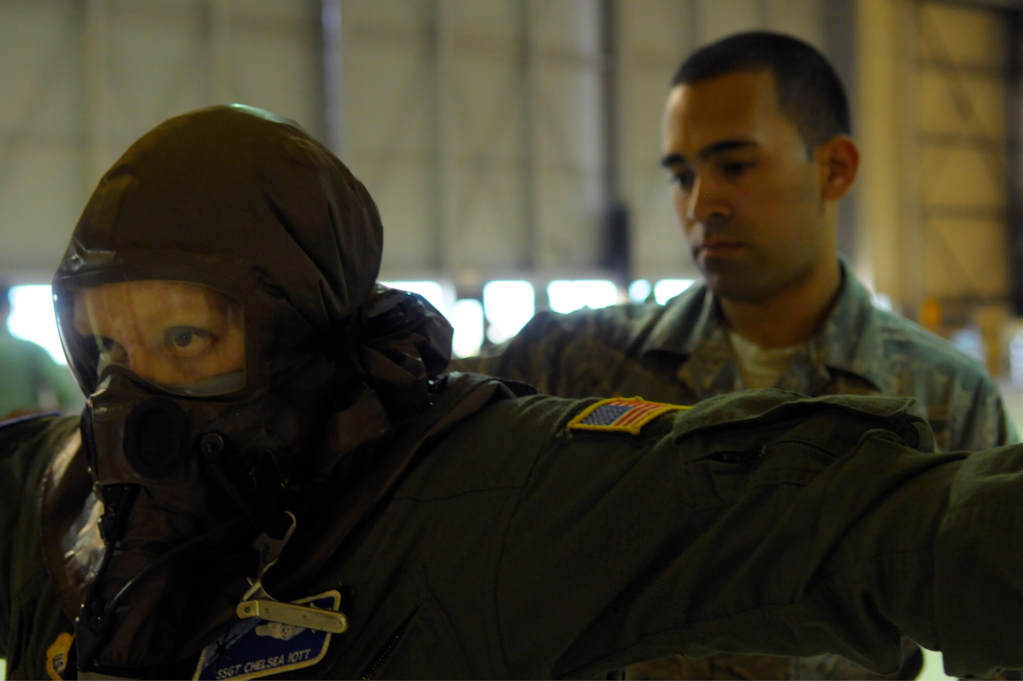 Staff Sgt. Chelsea Iott (left), 37th Airlift Squadron loadmaster, holds her arms up while Senior Airman Daniele Vezza (right), 86th Operation Support Squadron aircrew flight equipment technician, simulates checking her for chemical agents during a chemical-decontamination exercise here April 9. The 86th OSS sets up aircrew contamination control area lines in order to become familiar with the equipment and know what to do and expect in a chemical, biological, radiological or nuclear environment. (U.S. Air Force photo/Airman 1st Class Hailey Haux) 