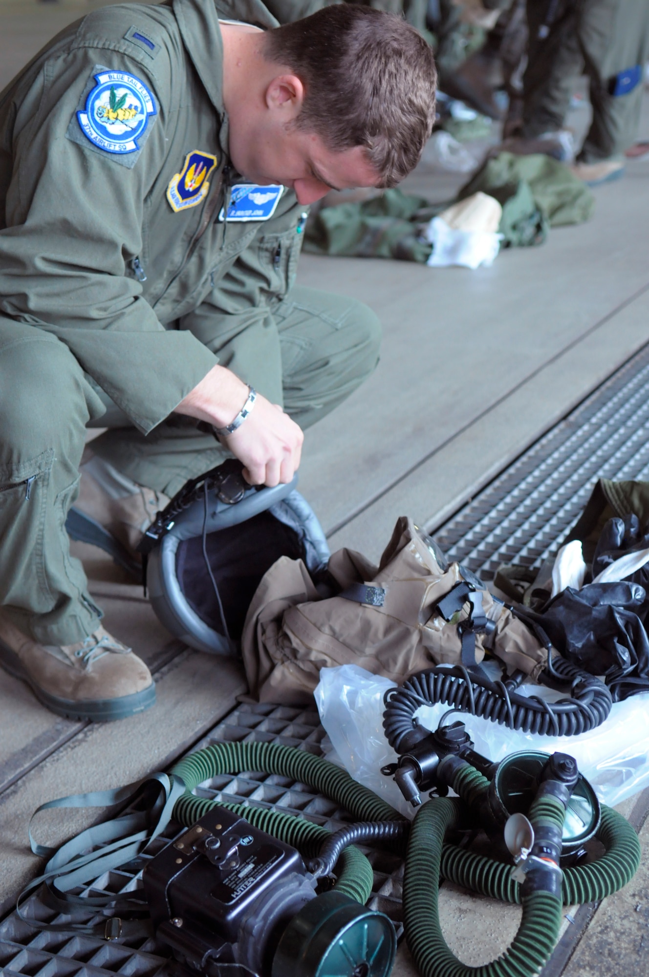 First Lt. R. Hunter John, 37th Airlift Squadron pilot checks his gear before putting it on during a chemical-decontamination exercise here April 9. The 86th Operation Support Squadron sets up aircrew contamination control area lines in order to become familiar with the equipment and know what to do and expect in a chemical, biological, radiological or nuclear environment. (U.S. Air Force photo/Airman 1st Class Hailey Haux)