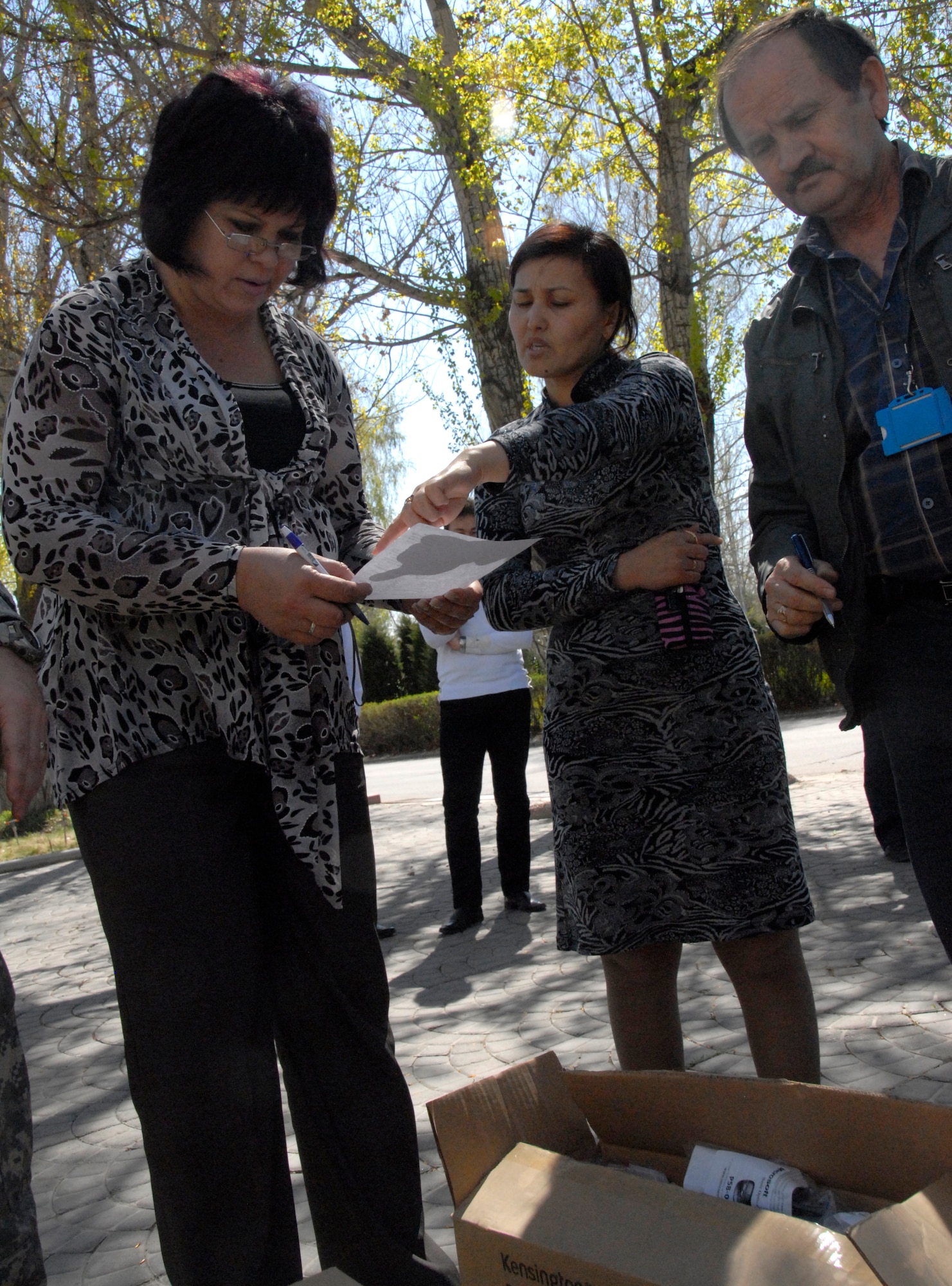 (Left to right) Tatiana Kudriashova, information systems engineer, Gulzat Kurmanbayeva, lawyer and Kamil Safiullin, head of the Air Traffic Control Center, look over shipping documents and the contents of boxes for an English language lab that has arrived at Manas International Airport, Kyrgyzstan, April 11, 2012. The lab will support long-range air traffic control and safety systems training to support air operations in the Kyrgyz Republic. (U.S. Air Force photo/Senior Airman Lynsie Nichols)