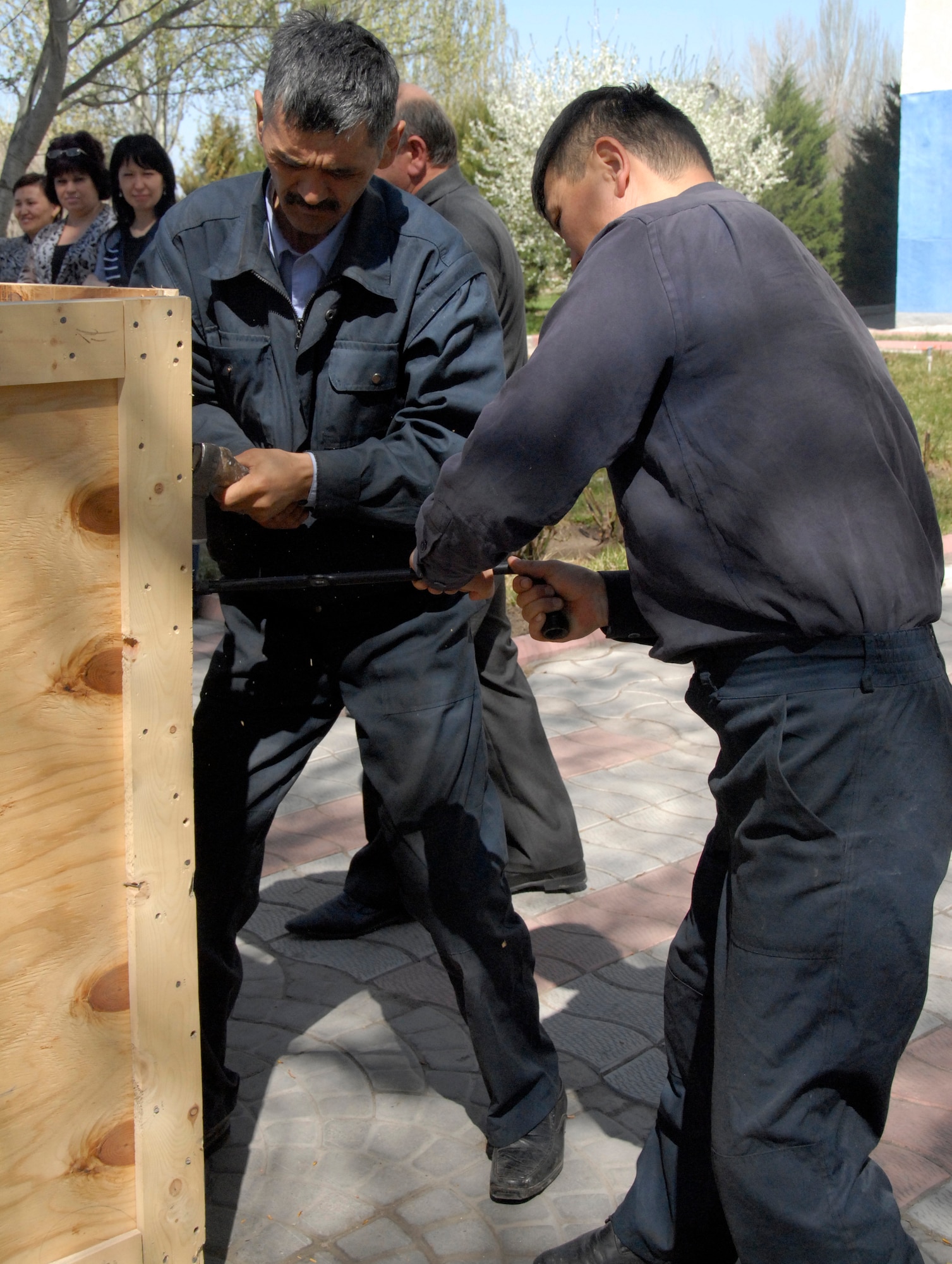 Ulan Moldoshev (left) and Kudash Moldoshev, warehouse laborers, open the sides of a crate containing equipment for an English language lab at the Manas International Airport, Kyrgyzstan, April 11, 2012. The English language lab will support long-range air traffic control and safety systems training to support air operations in the Kyrgyz Republic. (U.S. Air Force photo/Senior Airman Lynsie Nichols)