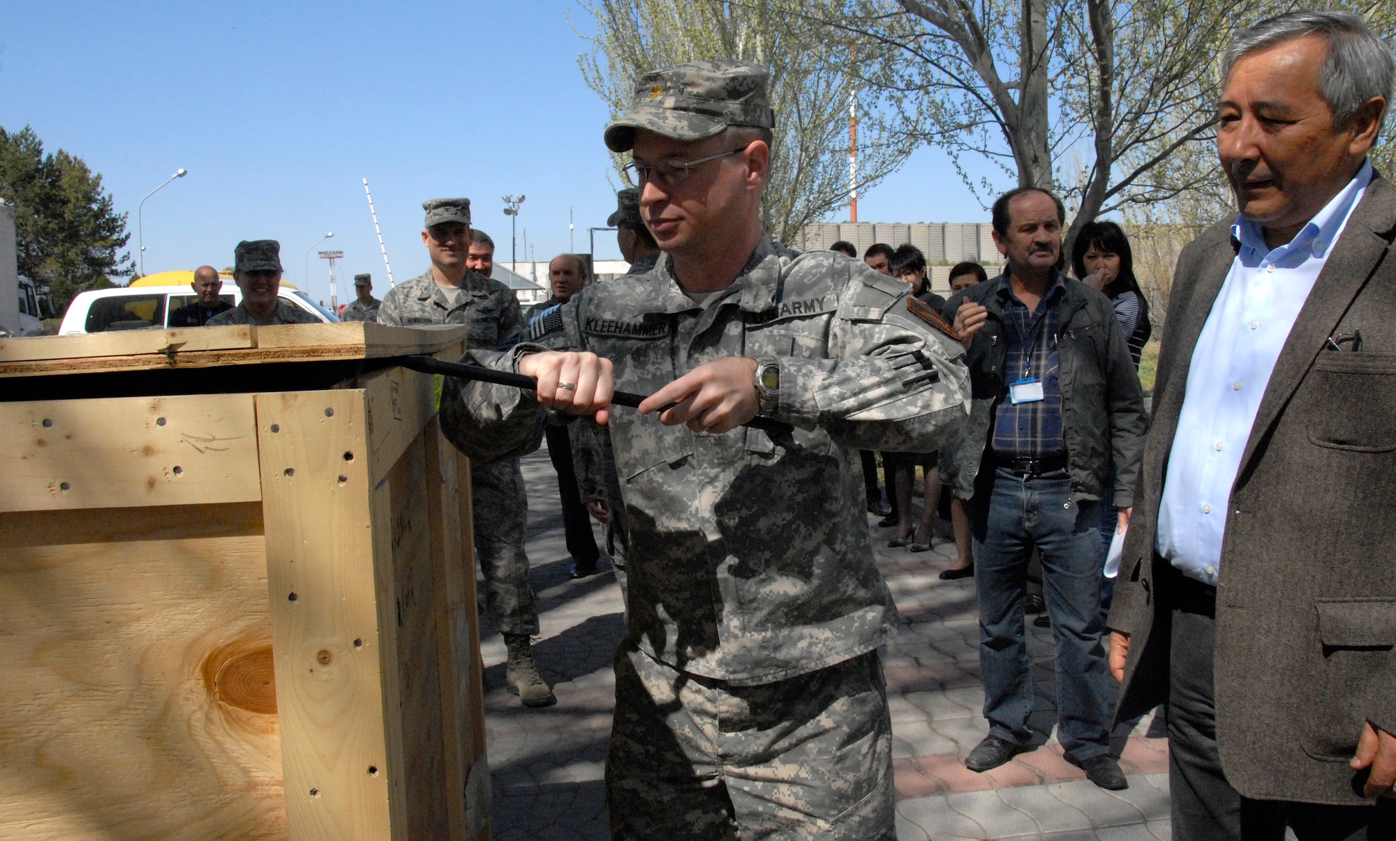 Maj. Joel Kleehammer, U.S. Embassy chief of office of military cooperation, opens a crate containing equipment for an English language lab at the Manas International Airport, Kyrgyzstan, April 11, 2012. The delivery included 10 student computer systems that will link together with one instructor computer. (U.S. Air Force photo/Senior Airman Lynsie Nichols)