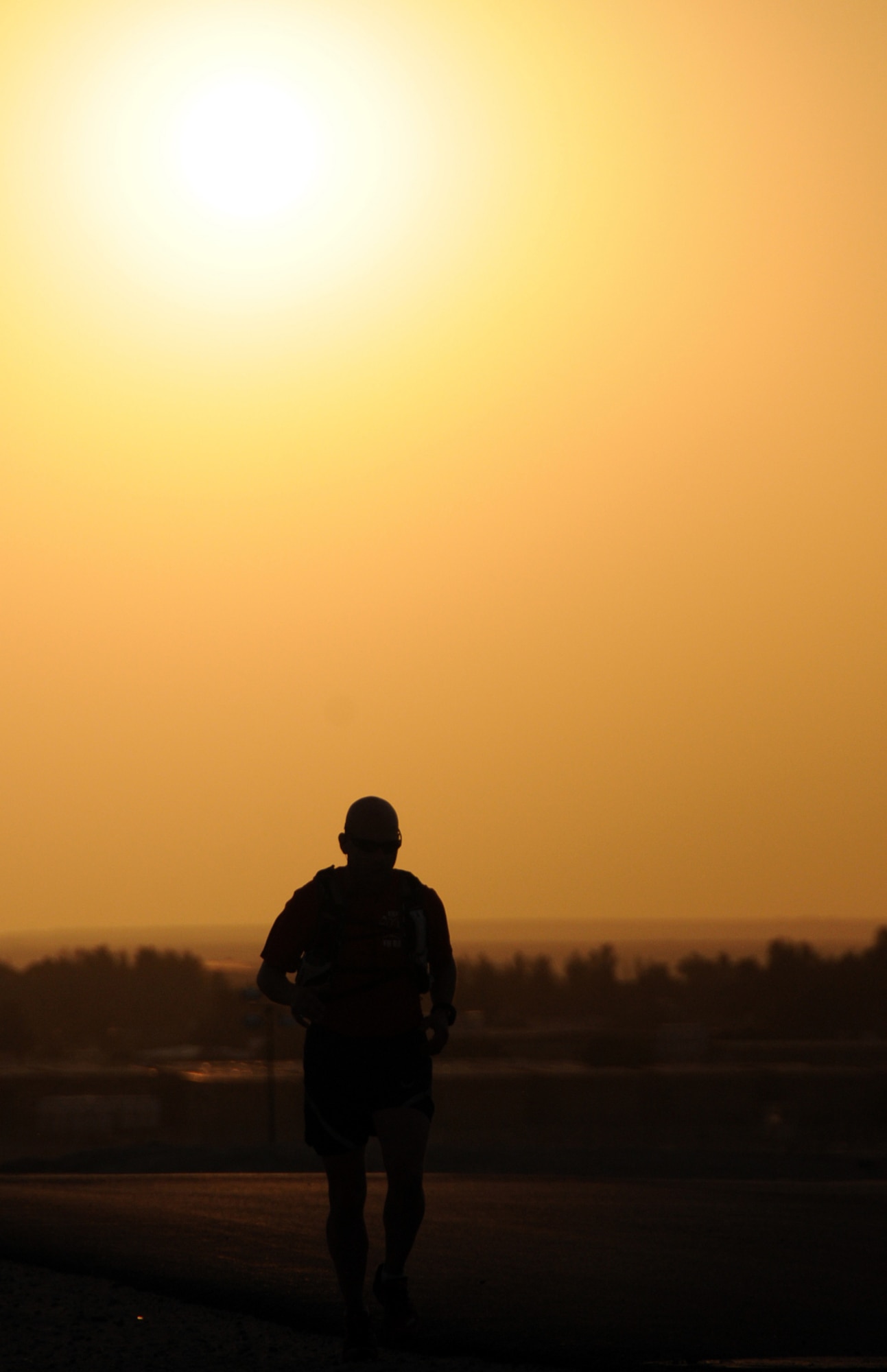 U.S. Air Force Tech. Sgt. Wayne Jenderny, 386th Expeditionary Civil Engineering Squadron firefighter, runs as the sun sets at an undisclosed location, Southwest Asia, April 7, 2012. Jenderny, a Minnesota Air National Guard member deployed from the 148th Fighter Wing and native of Eyota, Minn., ran 100 miles in less than 24 hours to raise awareness and take donations for a fellow firefighter's daughter who is suffering from a painful nerve disorder. (U.S. Air Force photo by Staff Sgt. James Lieth)