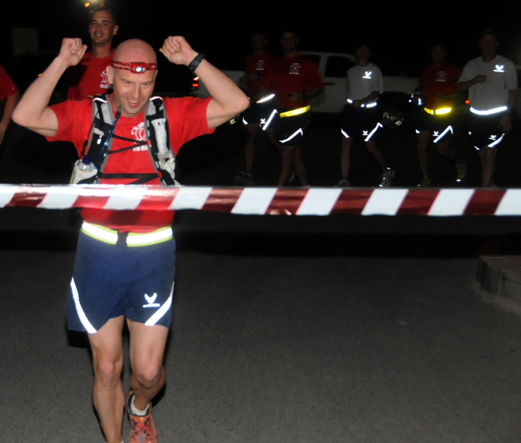 U.S. Air Force Tech. Sgt. Wayne Jenderny, 386th Expeditionary Civil Engineering Squadron firefighter, crosses the finish line after completing 100 miles in less than 24 hours at an undisclosed location, Southwest Asia, April 7, 2012. Jenderny, a Minnesota Air National Guard member deployed from the 148th Fighter Wing and native of Eyota, Minn., ran 100 miles in less than 24 hours to raise awareness and take donations for a fellow firefighter's daughter who is suffering from a painful nerve disorder. (U.S. Air Force photo by Staff Sgt. James Lieth)