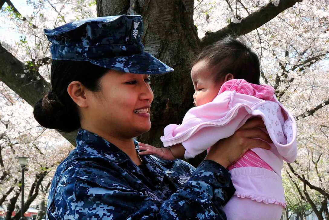 U.S. Navy Petty Officer 1st Class Charmaine Bacon spends time with her daughter during her lunch hour at a park on base in Yokosuka, Japan, April 12, 2012. The park's cherry blossom trees are in full bloom, which is a symbol of spring in Japan and occurs only once a year. Bacon is an information systems technician assigned to Commander, Fleet Activities Yokosuka.