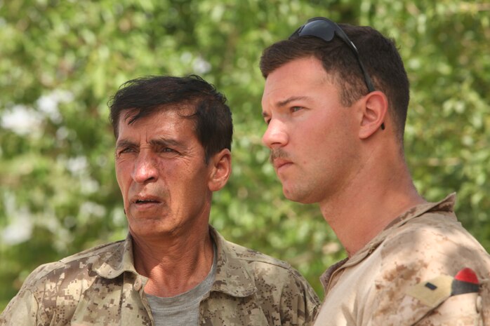 Major Muhammad Rahim Waziri, company commander serving with the Afghan National Civil Order Police here, talks to 1st Lt. Kevin J. Fitzsimmons, a platoon commander serving with Weapons Company, 1st Battalion, 8th Marine Regiment. The commanders held a meeting with local villagers to give everyone an open forum to ask questions and discuss issues in the community. (U.S. Marine Corps photo by Lance Cpl. Tyler Reiriz)