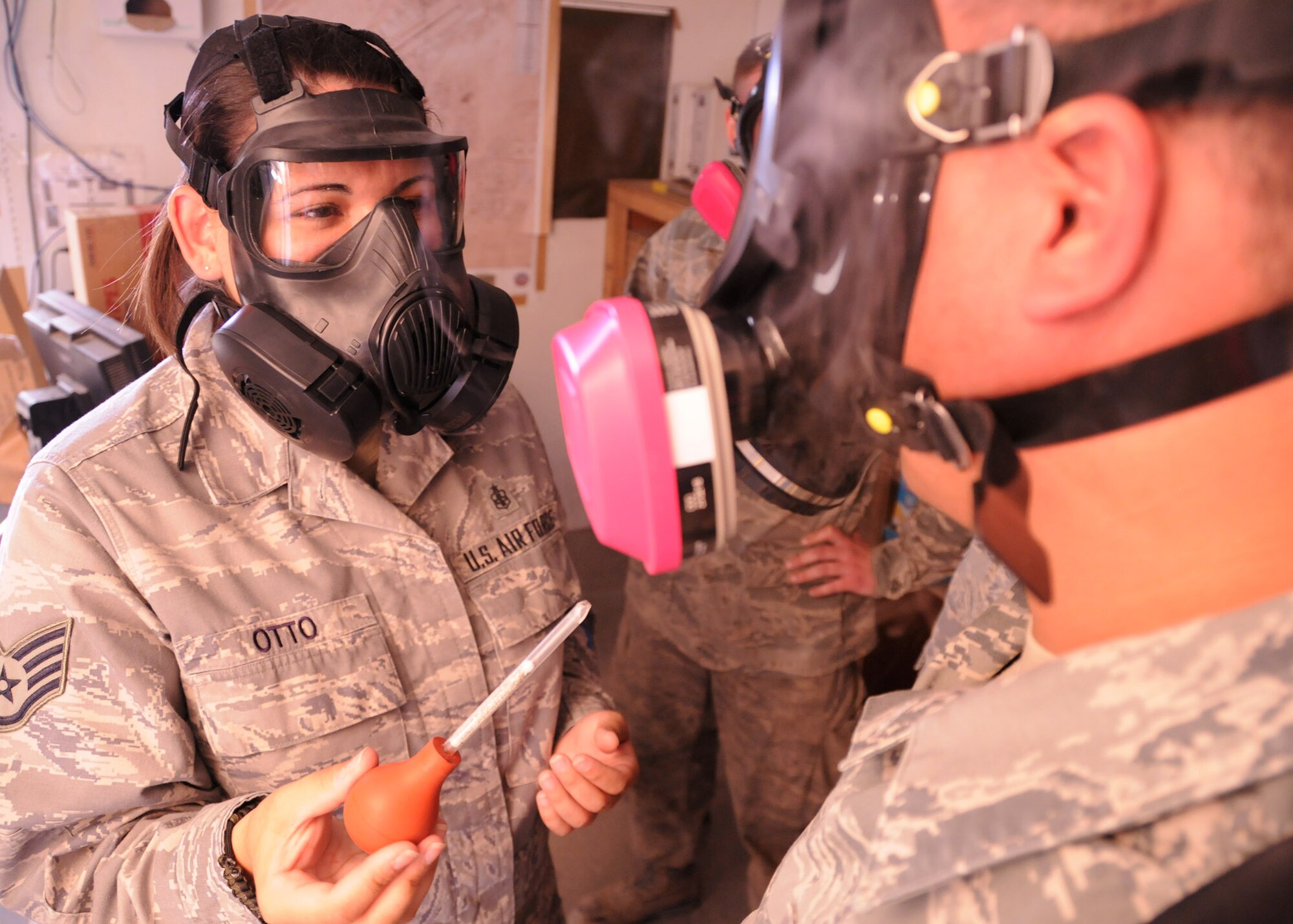Staff Sgt. Kayla Otto, 451st Air Expeditionary Wing bioenvironmental technician, fills the room with smoke to test the effectiveness of the respirators that maintenance and other Airmen wear to protect themselves from hazardous air pollutants here at Kandahar Airfield, Afghanistan, March 26, 2012. The smoke test is used in place of the machines used back in the United States. 