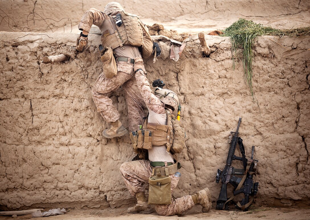 U.S. Marine Cpl. Enrique Torres (right), a squad leader with 1st Platoon, Kilo Company, 3rd Battalion, 3rd Marine Regiment, and a 21-year-old native of Alvarado, Texas, helps Lance Cpl. Joseph Hevia, a rifleman and 20-year-old native of Windsor, Calif., climb onto a roof while searching a compound with Afghan policemen during Operation Zema Parma Sar Tera (Don’t Tread On Me) here, April 14, 2012. Afghan National Security Forces and ‘America’s Battalion’ Marines are conducting a variety of missions throughout Helmand province’s Garmsir district ahead of the annual fighting season surrounding the harvest of illicit poppy crops.