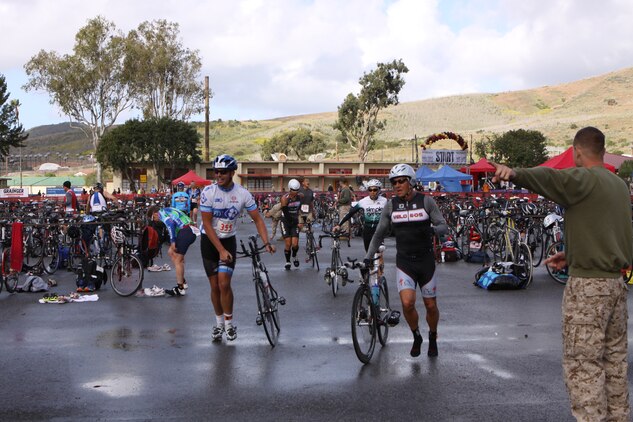 Participants run to exit the run to bike transition area to mount their bikes and begin the 30k cycling, during the Devil Dog Duathlon at Camp Pendleton, Calif., April 14.