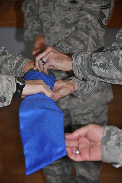 The banner of the 940th Communications Flight is sheathed during the unit's deactivation ceremony, April 15, 2012, at the Community Activity Center on Beale Air Force Base, Calif. The unit's mission will be realigned under the 940th Force Support Squadron. (U.S.Air Force photo by Senior Airman Adam Hamar)