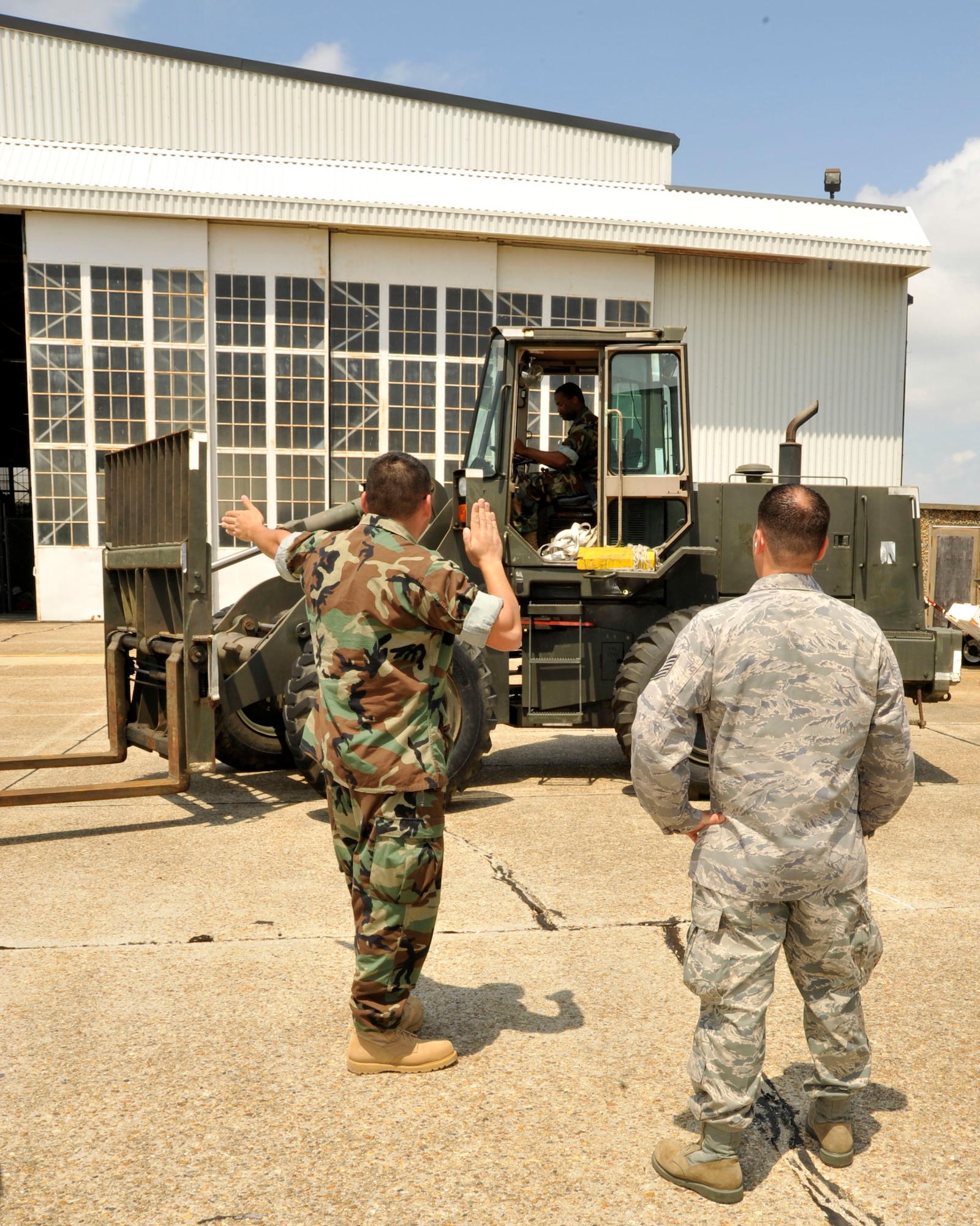 Tech. Sgt. Alex Cruz, 41st Aerial Port Squadron, oversees Electricians Mate 1st Class Gilberto Alvarez as he directs the forklift operator during a joint training exercise Apr. 14. Alaverez is assigned to Naval Cargo Handling Battalion 12 in Ft. Worth, Texas. He and other members of Naval Expeditionary Logistics Regiment 4 of the Naval Expeditionary Logistics Support Group, joined the 403rd Logistics Readiness Squadron and 41st APS to conduct training as part of the exercise Apr. 12-17. (U.S. Air Force photo by Maj. Heather Newcomb)