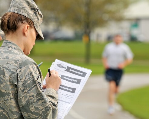 Master Sgt. Amanda Kapugi, 115th Force Support Squadron, prepares to log a lap time for her troop, Airman 1st Class Robert Miles, during an annual physical fitness test. Miles earned his second consecutive "Excellent" rating with an overall score of 99.5 percent on the test. Miles is also training for a marathon in Lincoln, Neb., for a chance to make the National Guard Marathon team which travels around the country to compete. Wisconsin Air National Guard photo by Tech. Sgt. Jon LaDue 
