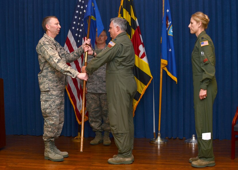 U.S. Air Force Lt. Col. James M. Mentges assumes command of the 135th Airlift Squadron, Maryland Air National Guard, by receiving the guide-on from Col. Thomas E. Hans, group commander, during a change of Command Ceremony on April 14, 2012 at Warfield Air National Guard Base, Baltimore, Md. after Lt. Col. April D. Vogel relinquishes her command.  (National Guard Photo By Staff Sgt. Benjamin Hughes/RELEASED)