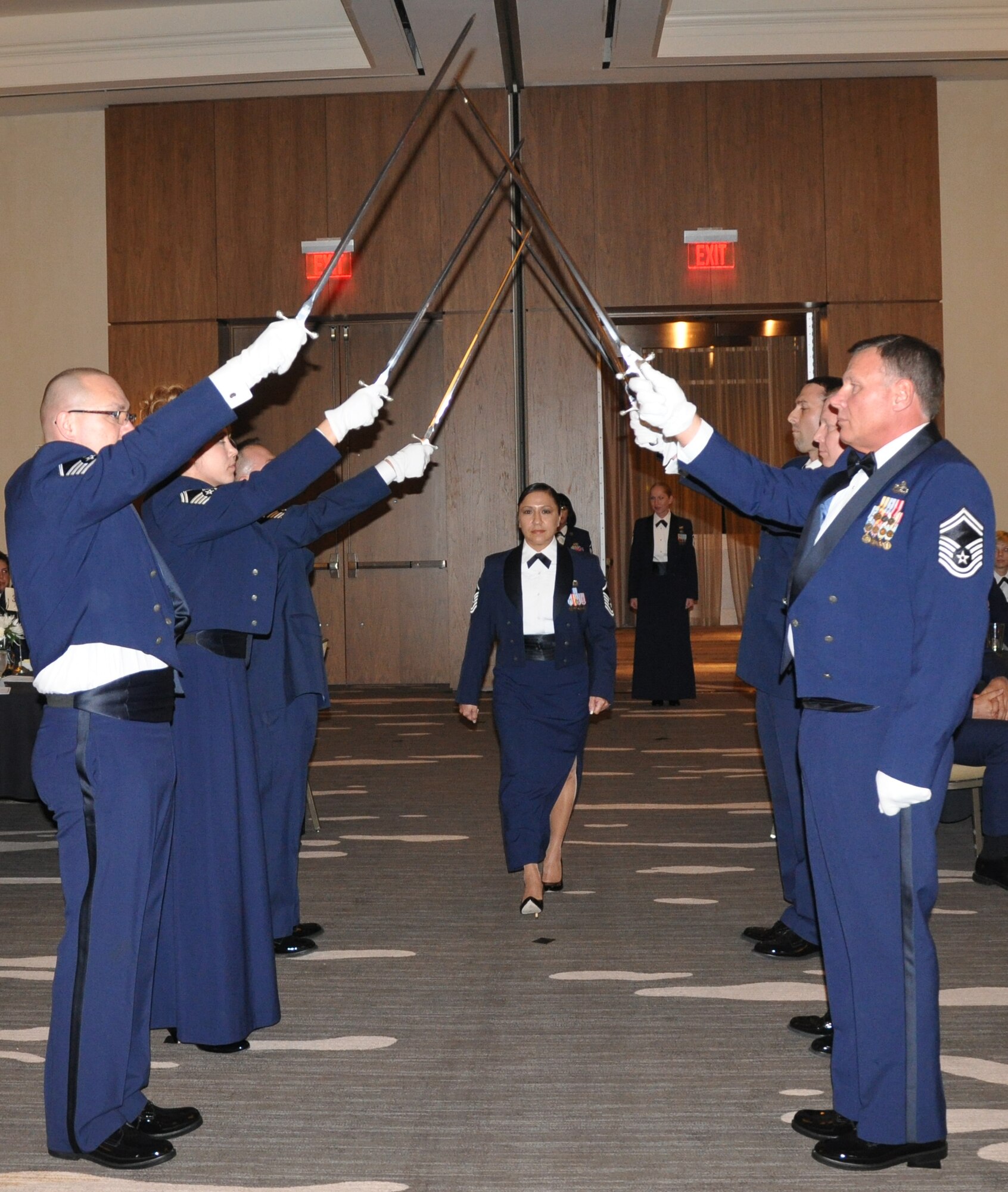 Master Sgt. Isabel De La Garza, 931st Operations Support Squadron, walks under the sword detail during the Senior NCO induction ceremony at the 931st Air Refueling Group annual awards banquet, April 14. (Air Force photo by Staff Sgt. Carrie Peasinger)