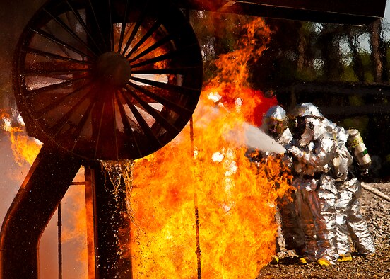 A team of firefighters from the 919th Special Operations Wing spray down a blazing engine during an aircraft fire exercise and training at Hurlburt Field, Fla., April 13.  More than 10 of Duke Field’s firemen braved the flames of the aircraft burn pit for this annual refresher training.  (U.S. Air Force photo/Tech. Sgt. Samuel King Jr.)