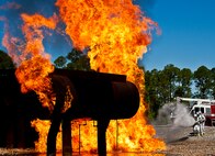A team of firefighters from the 919th Special Operations Wing move toward the blaze at an aircraft fire exercise and training at Hurlburt Field, Fla., April 13.  More than 10 of Duke Field’s firemen braved the flames of the aircraft burn pit for this annual refresher training.  (U.S. Air Force photo/Tech. Sgt. Samuel King Jr.)