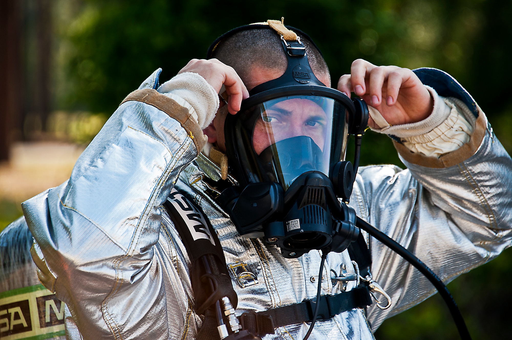 Senior Airman Samuel Cameron, a 919th Special Operations Wing firefighter, adjusts his gas mask prior to battling a blaze during an aircraft fire training scenario at Hurlburt Field, Fla., April 13.  More than 10 of Duke Field’s firemen braved the flames of the aircraft burn pit for this annual refresher training.  (U.S. Air Force photo/Tech. Sgt. Samuel King Jr.)