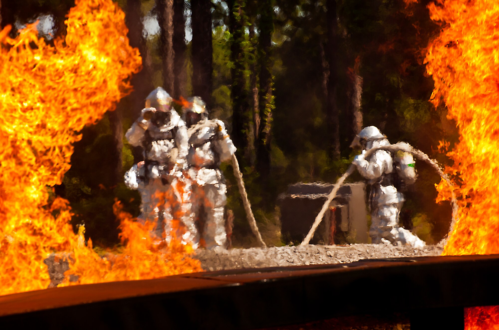A team of firefighters from the 919th Special Operations Wing prepare to battle 10-foot high flame walls at an aircraft fire exercise and training at Hurlburt Field, Fla., April 13.  More than 10 of Duke Field’s firemen braved the flames of the aircraft burn pit for this annual refresher training.  (U.S. Air Force photo/Tech. Sgt. Samuel King Jr.)