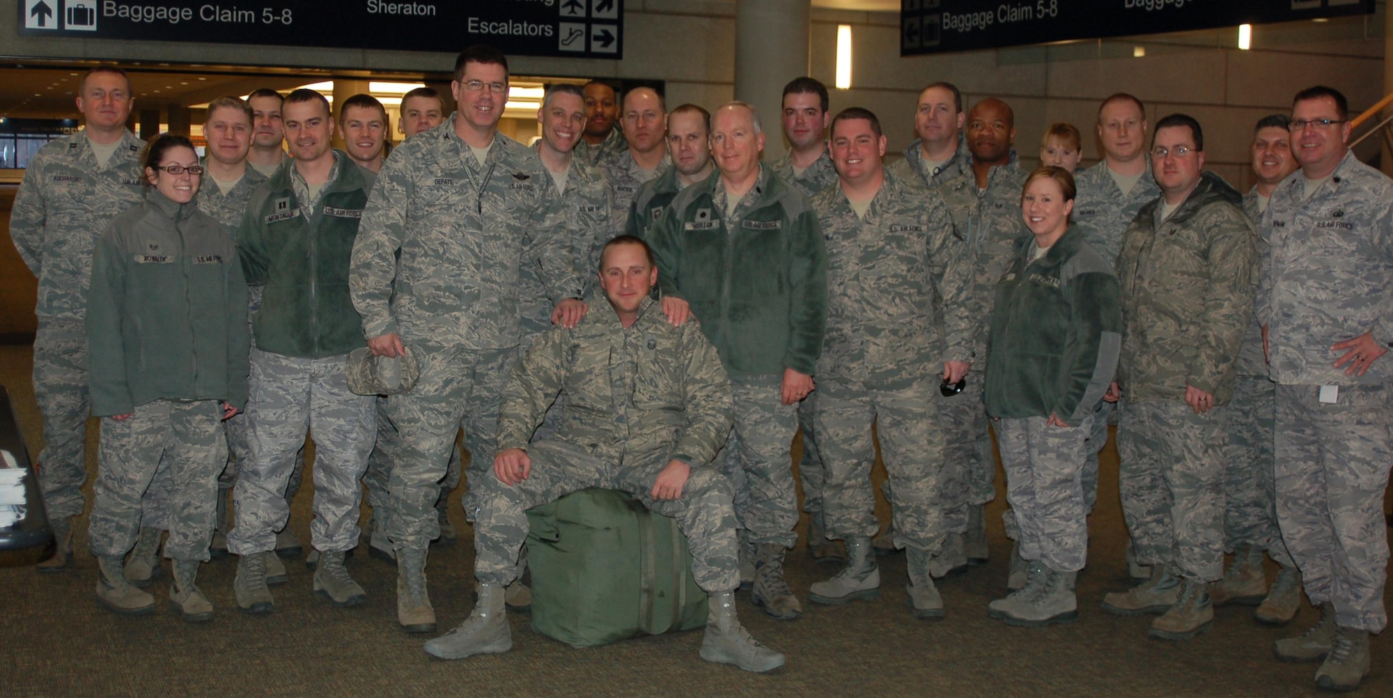 Master Sgt. Robert E. Bailey rests on his luggage and is surrounded by fellow members of the 103rd Air Operations Group who welcomed him home at Bradley International Airport Feb. 10, 2012, following an seven-month deployment to the Combined Air and Space Operations Center in Southwest Asia where he served as the Superintendent of the Targeting and Imagery Support Element. While deployed, Bailey was recognized for his excellence and selected to be the SNCO of the Year for the state of Connecticut. (U.S. Air Force photo by Capt. Jefferson S. Heiland)