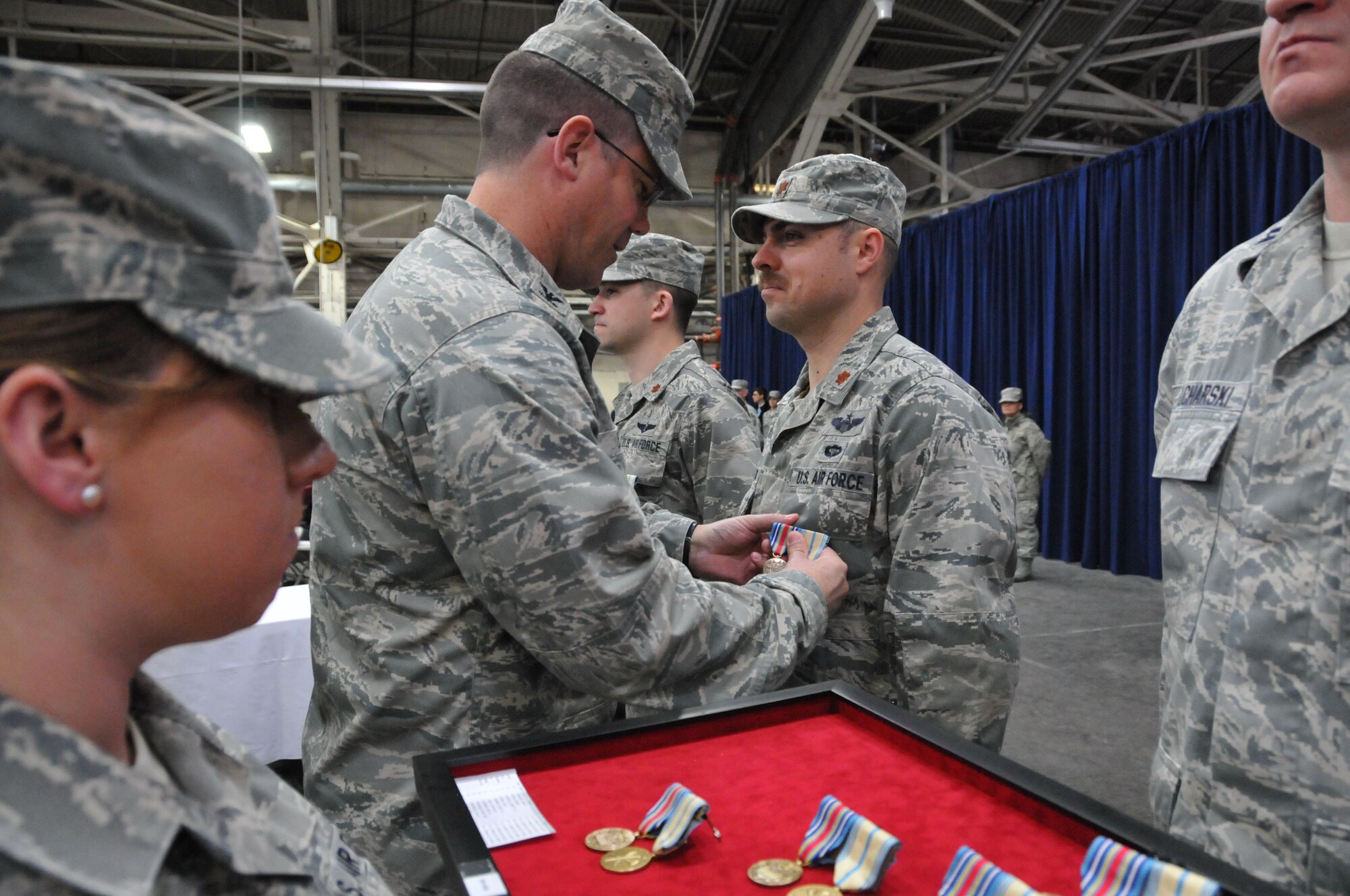 Col. Peter DePatie, 103rd Air Operations Group commander, pins medals on Maj. Greg Kozbinski during a Joint Freedom Salute Ceremony in the main hangar at Bradley Air National Guard Base in East Granby, Conn. March 31, 2012. Airmen and Soldiers of the Connecticut National Guard were formally welcomed home and honored following deployments over the past year. (U.S. Air Force photo by Tech. Sgt. Erin McNamara\RELEASED)