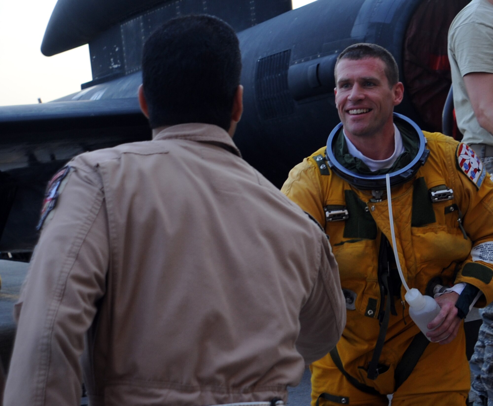 SOUTHWEST ASIA - Lt. Col. Andrew shakes hands with Lt. Col. Alberto on the flightline at the 380th Air Expeditionary Wing April 14, 2012. Andrew had just returned from a sortie in which he recorded his 1,000th flight hour in the U-2. Alberto achieved that same feat earlier in the month. Andrew, deployed from Beale Air Force Base, Calif., is the 99th Expeditionary Reconnaissance Squadron commander. For security reasons, U-2 pilots can only be identified by their first names. (U.S. Air Force photo/Staff Sgt. J.G. Buzanowski)