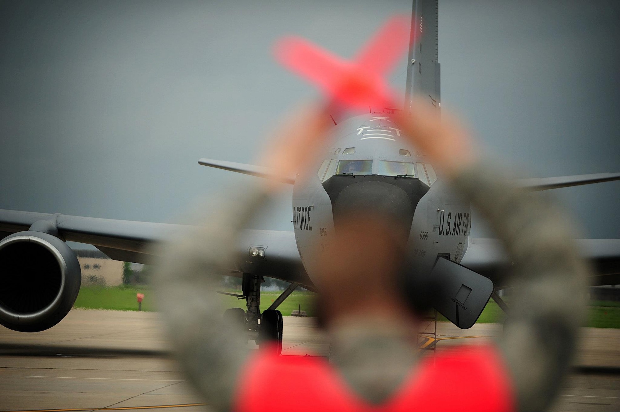 A McConnell Airman marshals a KC-135 Stratotanker April 14, 2012, McConnell Air Force Base, Kan. Late Friday evening, the National Weather Service and McConnell’s Weather Flight issued weather alerts about severe weather approaching Wichita with a significant potential for heavy precipitation, three-quarter-inch hail and high probability of a tornado. As a result, senior leaders elected to relocate 16 aircraft and shelter 10 in hangars. (U.S. Air Force photo/ Senior Airman Courtney Witt)