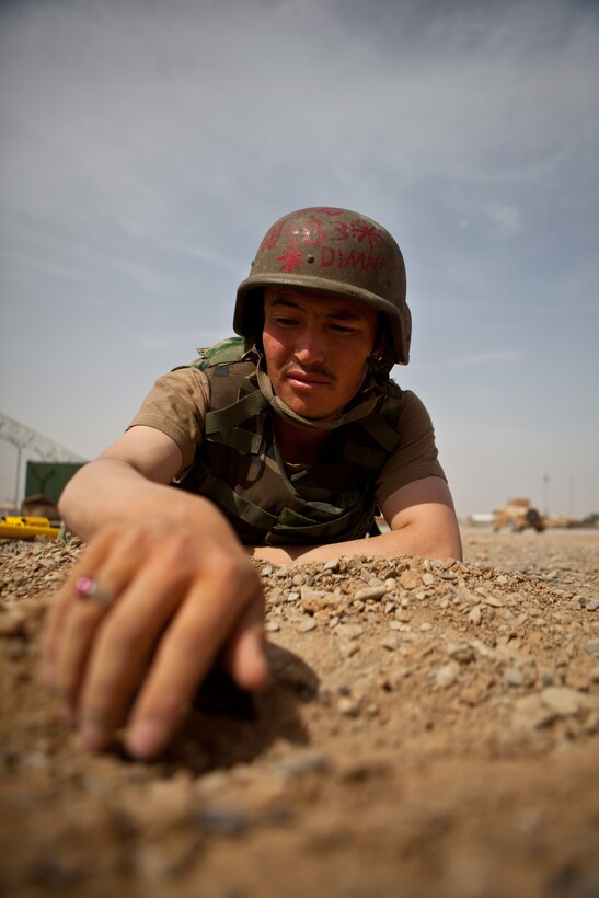 Afghan National Army Sgt. Din Mohammad, explosive ordinance disposal technician, Route Clearance Tolay, 2nd Brigade, 215th Corps, carefully unearths a mock improvised explosive device during EOD training, April 16, 2012. Din is receiving advanced EOD training from U.S. forces during a four-week program on base. His final test before certification is a real-world IED response mission. (Official U.S. Marine Corps photo by Staff Sgt. Brian Buckwalter)