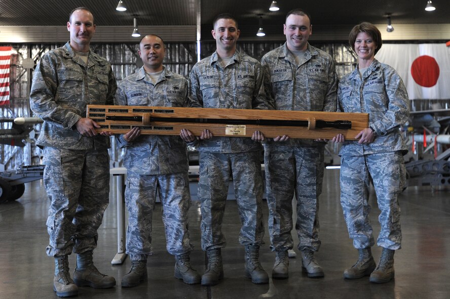 U.S. Air Force Lt. Col. Stephen Jost, left, 35th Operations Group deputy commander and Col. Cheryl Minto, right, 35th Maintenance Group commander, presents Staff. Sgt. Joseph Sundita, Airman 1st Class Christopher Bukarteck and Airman 1st Class Kenneth Taylor, 14th Aircraft Maintenance Unit weapons load crew members, with the load crew of the quarter trophy at Misawa Air Base, Japan, April 13, 2012. As the best weapons load crew of the quarter, Sundia's team won the competition with 925 points and a load time of 17:03. (U.S. Air Force photo by Airman Kenna Jackson/Released)