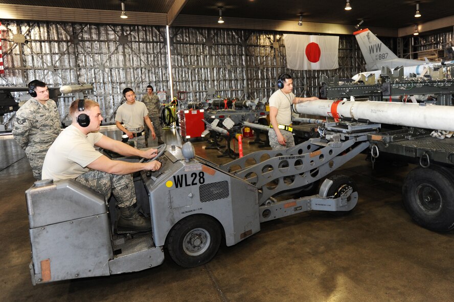 The weapons load crew representing the 13th Aircraft Maintenance Unit uses an MJ-1 lift truck to transport an AIM-120 advanced medium-range air-to-air missile to the F-16 Fighting Falcon aircraft during the 35th Aircraft Maintenance Squadron's load crew of the quarter competition at Misawa Air Base, Japan, April 13, 2012. The MJ-1, also called a jammer, has a lifting capacity of 3,000 pounds and is used to load and unload munitions. (U.S. Air Force photo by Airman Kenna Jackson/Released)