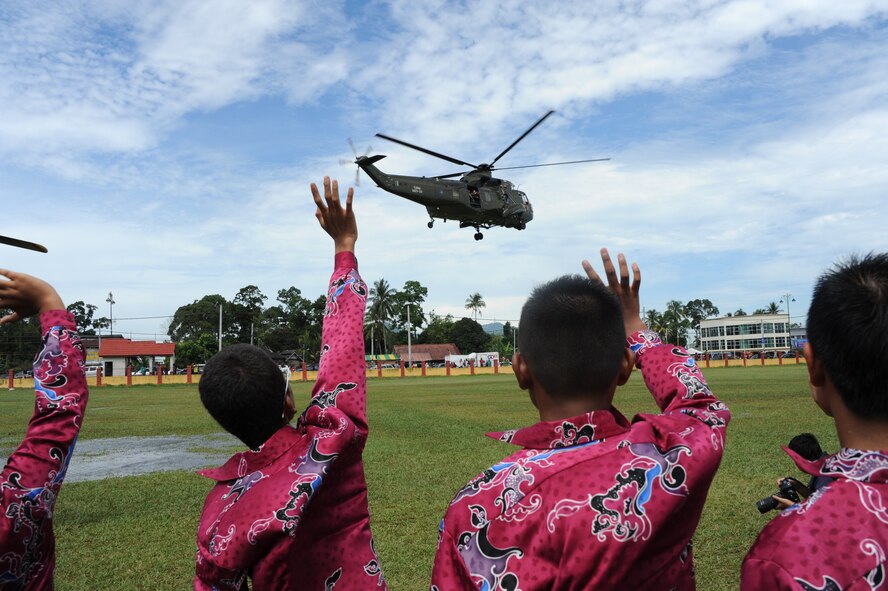 Orphans from the Pertubuhan Pembangunan Anak-Anak Yatim Bekas Perajurit orphanage in Kulim, Malaysia, wave goodbye to distinguished visitors who attended a dedication ceremony at the orphanage April 13, 2012. Royal Malaysian Air Force and U.S. Air Force airmen built a multi-use sports court at the orphanage during Cope Taufan 2012. (U.S. Air Force photo/Master Sgt. Matt Summers)