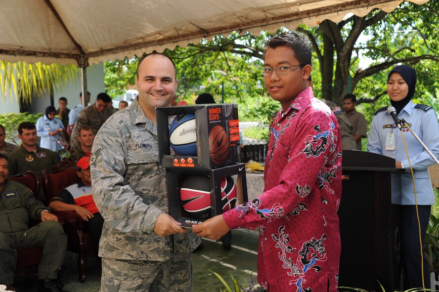 Senior Airman Shawn Flowers, 67th Aircraft Maintenance Unit support flight, presents basketballs to Mohd Fahmi Bin Ahmad, an orphan at the Pertubuhan Pembangunan Anak-Anak Yatim Bekas Perajurit orphanage in Kulim, Malaysia, during a ceremony April 13, 2012. Royal Malaysian Air Force and U.S. Air Force airmen built a multi-use sports court at the orphanage during Cope Taufan 2012. (U.S. Air Force photo/Master Sgt. Matt Summers)