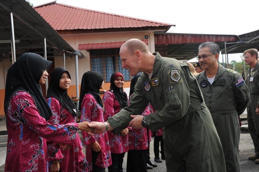 Col. Patrick Malackowski (center), vice commander of 13th Air Force at Joint Base Pearl Harbor Hickam, Hawaii, and Royal Malaysian Air Force Brig. Gen. Abdul Mutalib Ab Wahab, greet orphans at the Pertubuhan Pembangunan Anak-Anak Yatim Bekas Perajurit orphanage in Kulim, Malaysia, shortly before a dedication ceremony April 13, 2012. RMAF and U.S. airmen built a multi-use sports court at the orphanage during Cope Taufan 2012. (U.S. Air Force photo/Master Sgt. Matt Summers)