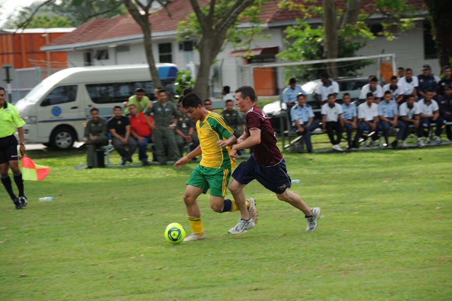 Royal Malaysian Air Force 1st Lt. Tajudin Syafiq, No. 12 Squadron pilot candidate, moves upfield against Staff Sgt. Kyle Reiley, 67th Aircraft Maintenance Unit crew chief, during a soccer match as part of Cope Taufan 2012 at TUDM Butterworth April 12, 2012. U.S. and RMAF airmen competed in soccer, volleyball and sepak takraw, a traditional Malaysian sport, as part of a camaraderie and friendship building event. Sports have long played and important role in building esprit de corps and physical fitness in both countries militaries. Cope Taufan is a live-flying exercise designed around dissimilar basic fighter maneuvers and dissimilar air combat tactics training. (U.S. Air Force photo/Master Sgt. Matt Summers)