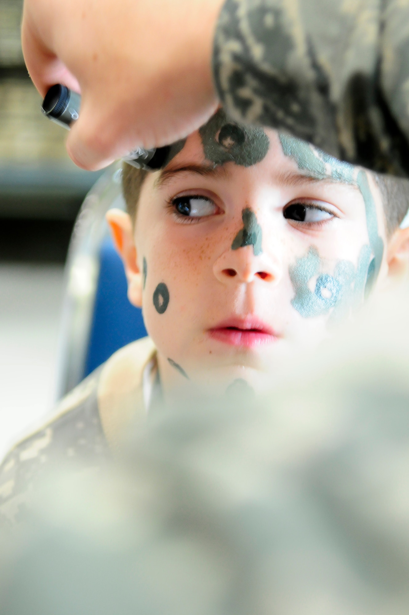 GOODFELLOW AIR FORCE BASE, Texas -- Landen Knox, 6, son of Staff Sgt. Austin Knox, 17th Training Wing Public Affairs, "prepares for war" in support of Operation Kids by
having camouflage paint applied April 14.  The mock deployment event gives
military youths a glimpse of what their parents go through using a series of
educational activities. (U.S. Air Force photo/Staff Sgt. Austin Knox)
