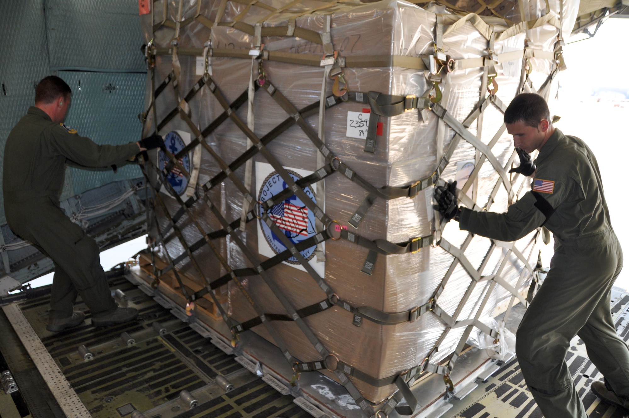 Master Sgt. Scott O'Brien (left), and Staff Sgt. Brandon Ward, two 709th Airlift Squadron loadmasters assigned to Dover Air Force Base, Del., load a pallet of cargo onto a C-5 April 13, 2012, in support of the U.S. Navy's Project Handclasp. A 19-member all-Reserve aircrew hauled 34 pallets totalling more than 110,000 pounds of goods, ranging from medical supplies to educational material, to Naval Station Rota, Spain, where it would be further delivered to seven countries in Africa as part of the Navy's humanitarian assistance program. (U.S. Air Force photo/Master Sgt. William Adkins)