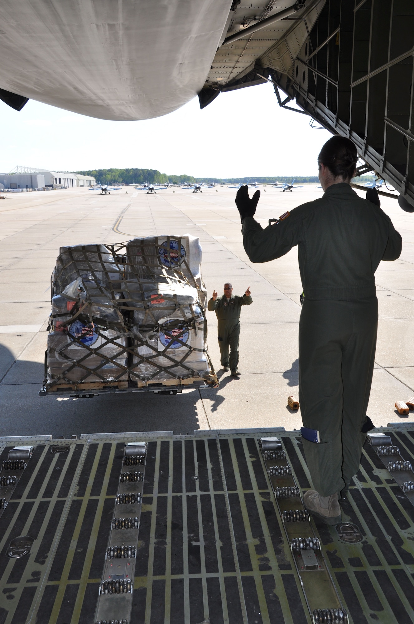 Tech. Sgt. Sarai Goldsberry (right), 709th Airlift Squadron loadmaster, guides a pallet of cargo onto a C-5 aircraft April 13, 2012, at Oceana Naval Air Station, Va., with the assistance of Master Sgt. Charles Groce, also assigned to the 709th AS . The all Reserve aircrew from Dover Air Force Base, Del., supported the U.S. Navy's Project Handclasp humanitarian mission by hauling more than 110,000 pounds of cargo to Naval Station Rota, Spain. (U.S. Air Force photo/Master Sgt. Lucious Washington)