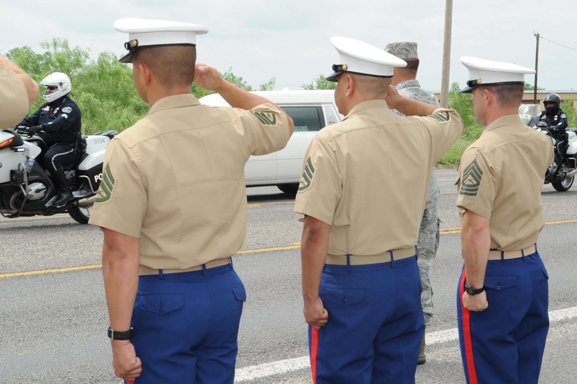 GOODFELLOW AIR FORCE, Texas -- Marines line Chadbourne Street in front of Jacobson Gate April 13 to honor former San Angelo police officer Jaime Padron who was killed in the line of duty April 6. Padron served in the Marine Corps for eight years and with the San Angelo Police Department for 14 years before moving to Austin. More than 80 base personnel lined the street showing their respect. (U.S. Air Force photo/Staff Sgt. Laura R. McFarlane)