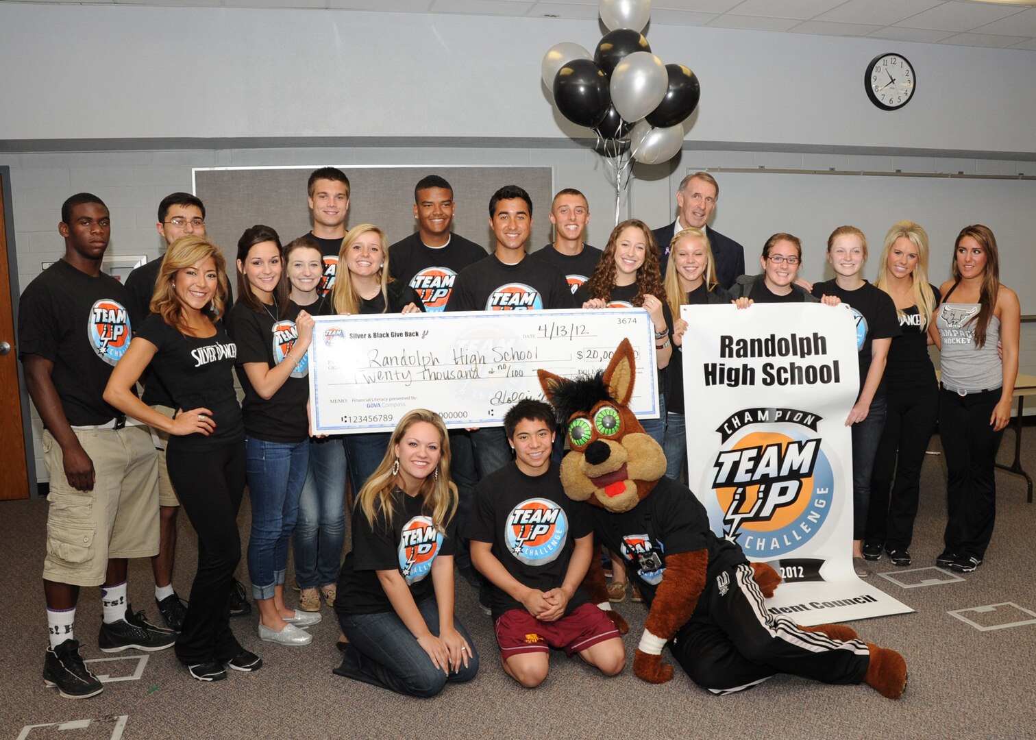 The San Antonio Spurs representives presents a $20,000 check to the Randolph High School Student Council April 13. The student council was selected for their DriveSMART campaign by the Silver and Black Give Back’s Team Up Challenge. (U.S. Air Force photo by Melissa Peterson)