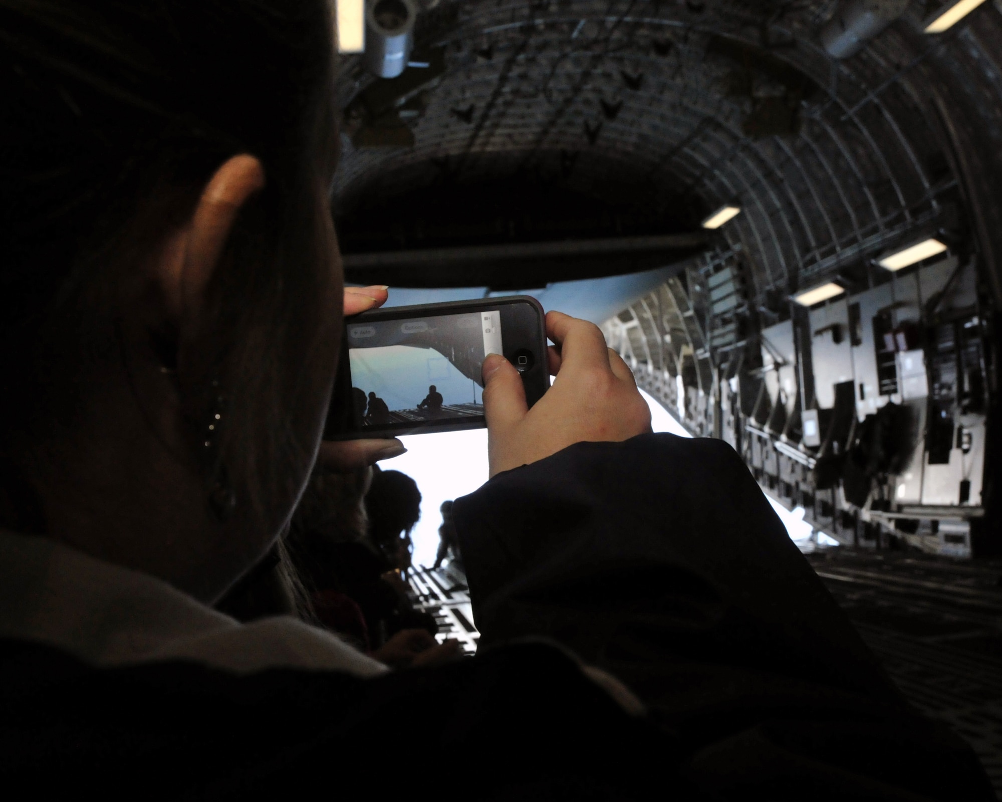 A spouse of the 62nd Operations Group takes a photograph of the view from open ramp doors while flying on a C-17 Globemaster III April 14, 2012, at Joint Base Lewis-McChord, Wash. The 62nd OG hosted an orientation flight where spouses had an opportunity to view Mt. Rainier and the Washington state coastline. (U.S. Air Force photo/Staff Sgt. Frances Kriss)