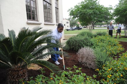 Staff Sgt. Tausha Walker, Air Education and Training Command directorate of medical services and training public health craftsman, spreads mulch around Bldg. 671 on Joint Base San Antonio-Randolph, Texas April 12. The unit was landscaping the building during I Love Randolph week. (U.S. Air Force photo by Rich McFadden) 
