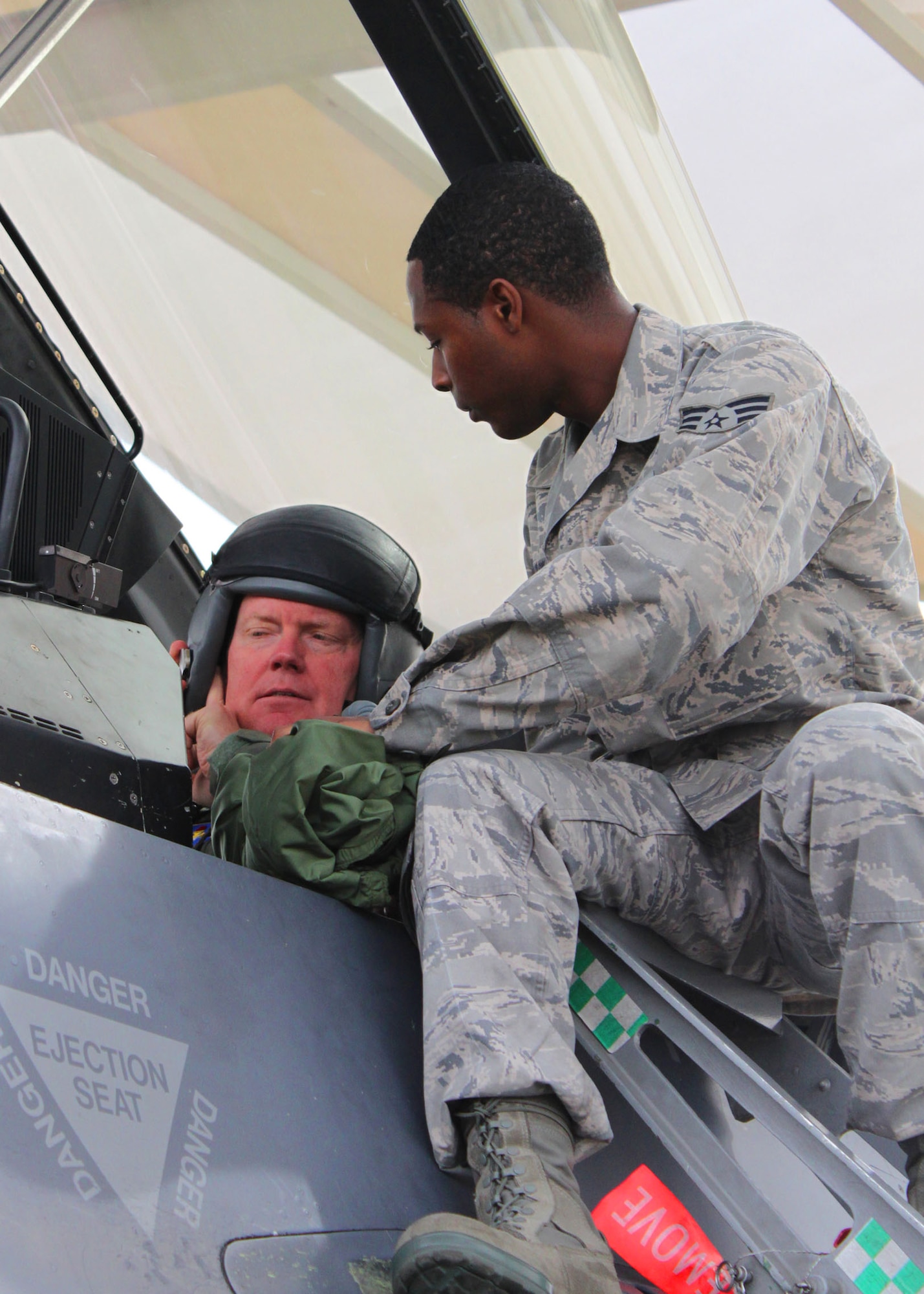 Senior Airman Dominique Wilson, F-16 Dedicated Crew Chief, 308th Aircraft Maintenance Unit, helps Maj. Gen. Mike Skinner, Mobilization Assistant, Air Education and Training Command, prepare for an F-16 flight from Luke Air Force Base, Ariz., April 5. (U.S. Air Force Photo by Tech Sgt. Meredith Mingledorff)