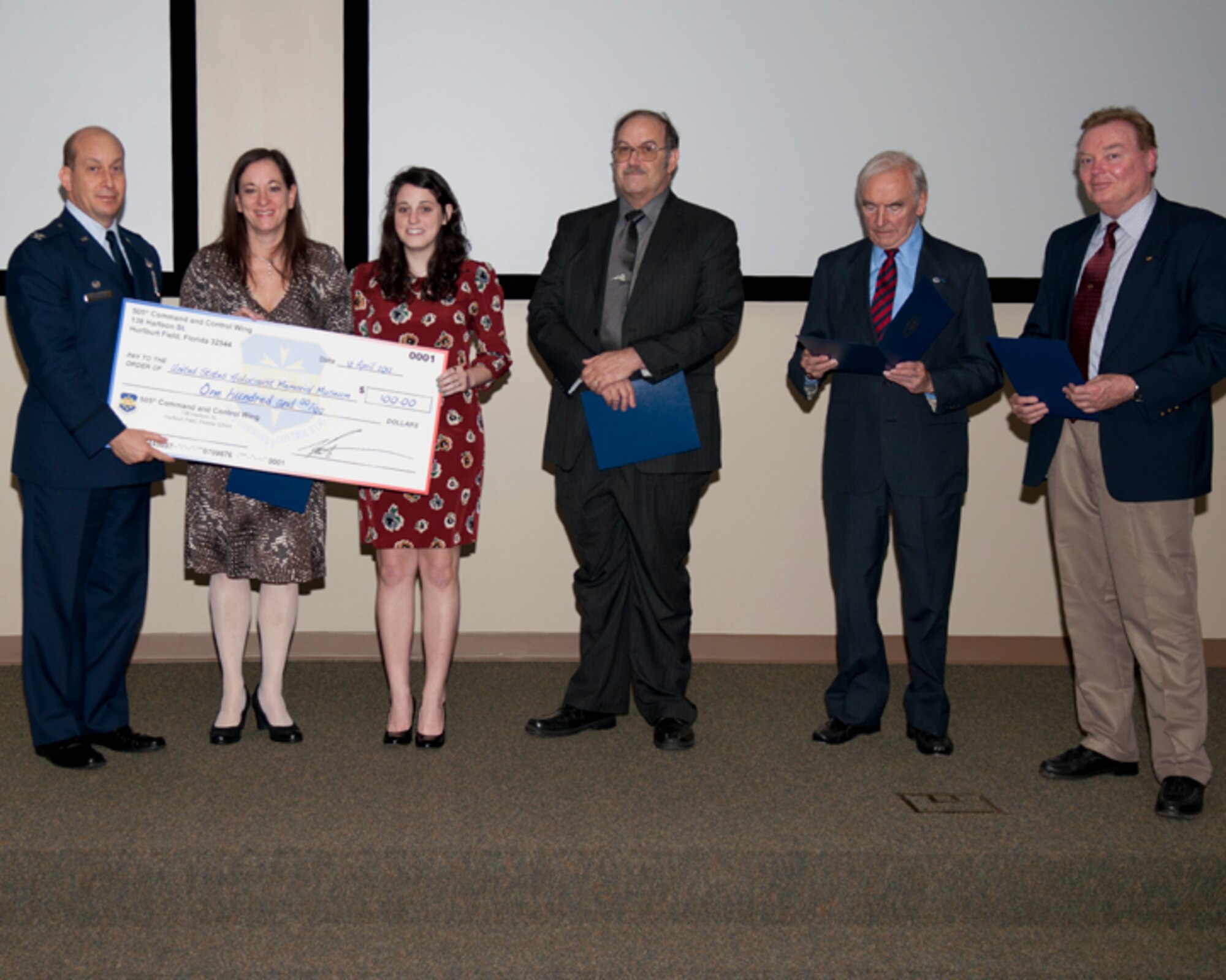 (From left to right) Col. Mustafa Koprucu, commander of 505th Command and Control Wing, Dr. Lori Ripps, Hannah Ripps, Dr. Robert Kane, Joseph Callewaert and Dr. Derek Zumbro pose with a check donation during a Holocaust Remembrance Ceremony at the 505th Training Squadron Auditorium at Hurlburt Field, Fla., April 12, 2012. A donation was made on behalf of the 505th CCW and the 1st Special Operations Wing to the United States Holocaust Memorial Museum in honor of the presenters and their families. (Courtesy photo) 
