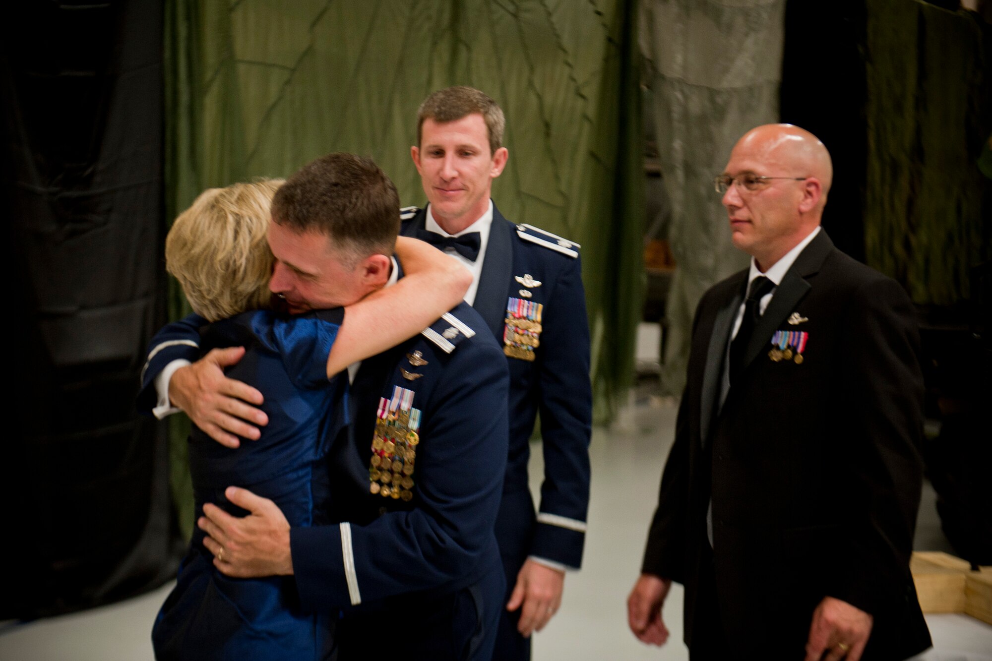 Dawn Goldfein, wife of U.S. Air Force Lt. Gen. David Goldfein, commander, Air Force Central Command, embraces Lt. Col. Tom Kunkel, Lt. Col. Bill Deneahan and retired Master Sgt. Jack Gainer after giving remarks during the 347th Rescue Group Rescue Warrior Ball at Moody Air Force Base, Ga., April 13, 2012. Kunkel, Deneahan and Gainer were members of a crew who safely brought home Goldfein after his aircraft was shot down by enemy forces over Serbia during Operation Allied Force in 1999. (U.S. Air Force photo by Staff Sgt. Jamal D. Sutter/Released)  