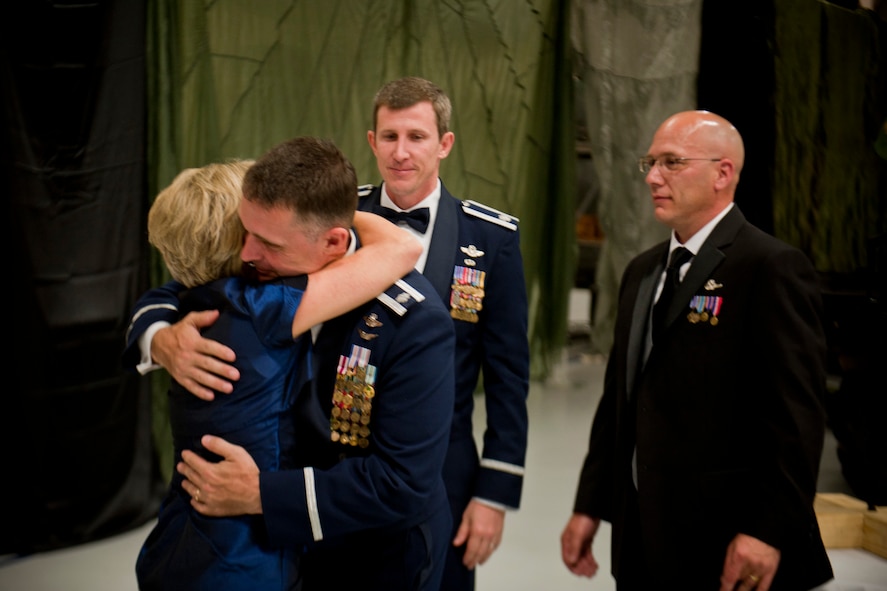 Dawn Goldfein, wife of U.S. Air Force Lt. Gen. David Goldfein, commander, Air Force Central Command, embraces Lt. Col. Tom Kunkel, Lt. Col. Bill Deneahan and retired Master Sgt. Jack Gainer after giving remarks during the 347th Rescue Group Rescue Warrior Ball at Moody Air Force Base, Ga., April 13, 2012. Kunkel, Deneahan and Gainer were members of a crew who safely brought home Goldfein after his aircraft was shot down by enemy forces over Serbia during Operation Allied Force in 1999. (U.S. Air Force photo by Staff Sgt. Jamal D. Sutter/Released)  
