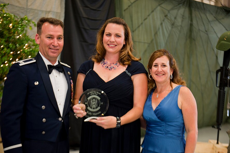 Kelly Mustain, wife of U.S. Air Force Capt. Matthew Mustain, 41st Rescue Squadron, receives the 347th Rescue Group Key Spouse of the Year award from Col. Chad Franks, 347th RQG commander, and his wife, Kim, during the 347th RQG Rescue Warrior Ball at Moody Air Force Base, Ga., April 13, 2012. Mustain earned the award for her various contributions to the unit through fund raisers and other events. (U.S. Air Force photo by Staff Sgt. Jamal D. Sutter/Released)