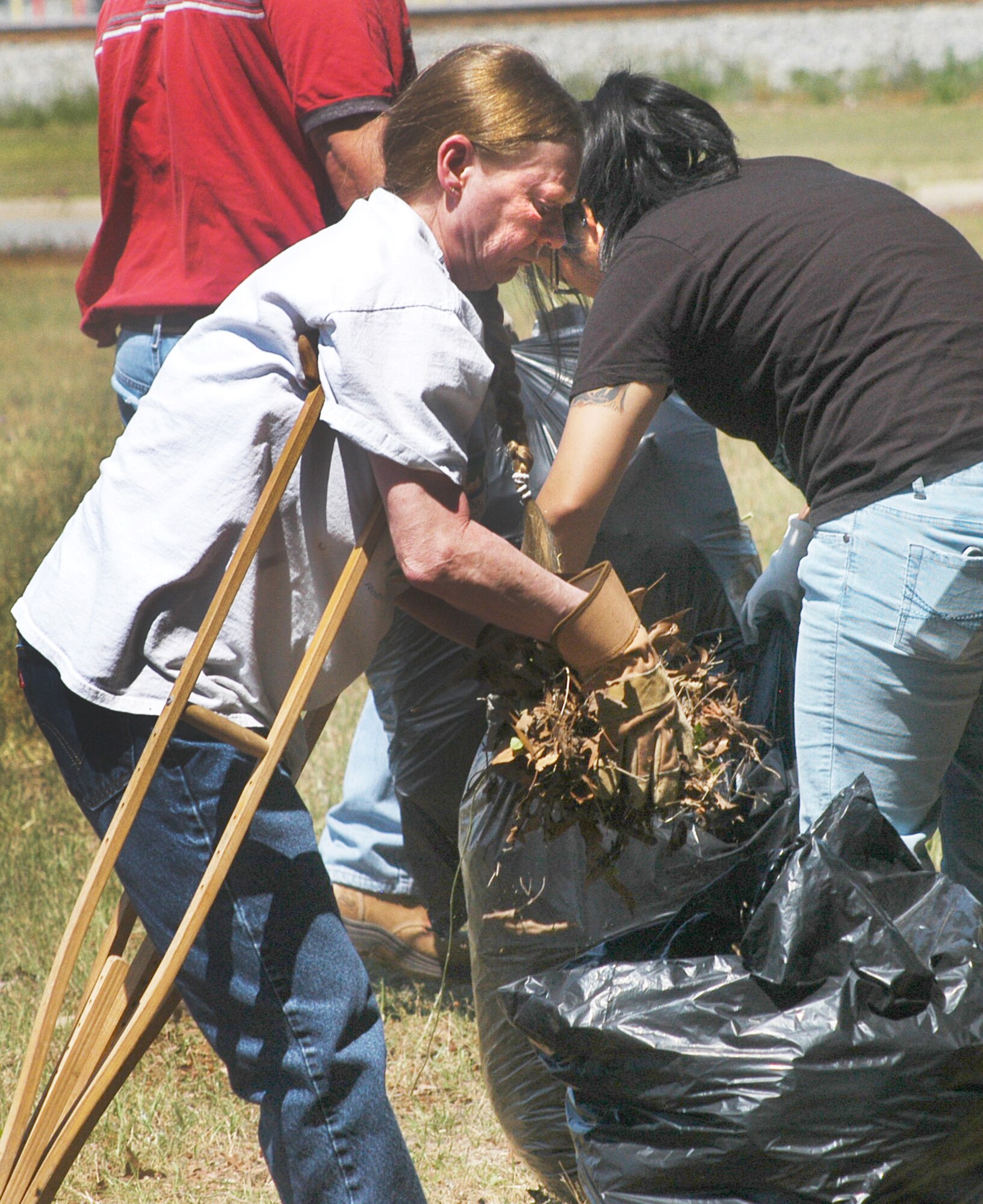 Christl Kohls, Air Force Reserve Command, fills a bag with leaves and debris during clean-up at Bryant Cemetery in Warner Robins. The clean-up is part of observance activities for Robins Earth Day. (U. S. Air Force photo by Sue Sapp)