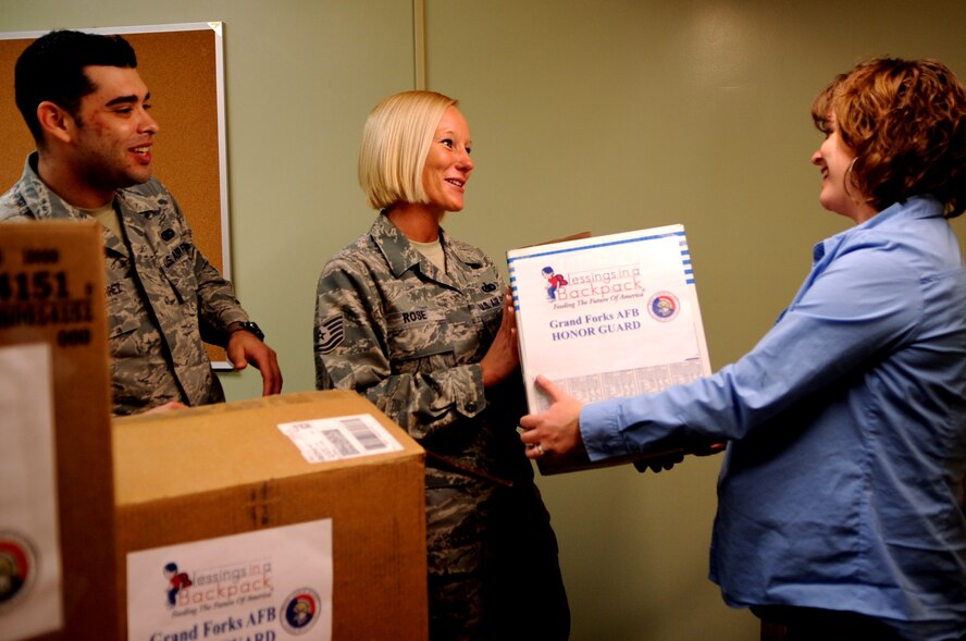 Senior Airman Luis Loza-Gutierrez (left), 319th Air Base Wing, and Tech. Sgt. Stephanie Rose, 319th Air Base Wing Honor Guard Program Manager, deliver donated food to Laura McLaurin, a counselor at Sweetwater Elementary School in Devils Lake, N.D., on April 12, 2012. The Honor Guard has adopted the school and the food is meant to help feed children who all too often go hungry over the weekends.  (U.S. Air Force photo by Staff Sgt. Amanda N. Grabiec)