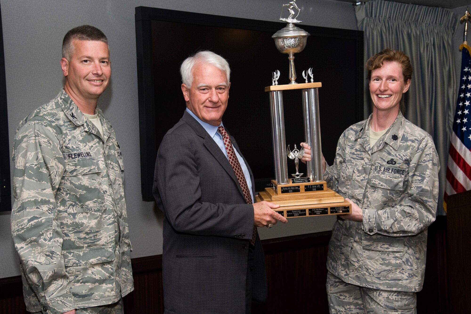 Col. Jeffrey Flewelling (left), 21st Space Wing vice commander, accepts the Snofest trophy on behalf of Peterson AFB from Lt. Col. Ann Igl, 21st Force Support Squadron commander, and Bill Gessner, Special Assistant to the Chief of Staff for Command Support, NORAD/USNORTHCOM, April 11 in the 21st SW conference room. This was the fourth year in a row that Peterson AFB walked away with the commander's cup. The annual Snofest event was held in January at Keystone, Colo., and featured special lodging deals, discounted lift tickets, ski and snowboard races, wine and beer tastings, sleigh rides, gondola rides, live music and more. (U.S. Air Force photo/Craig Denton)
