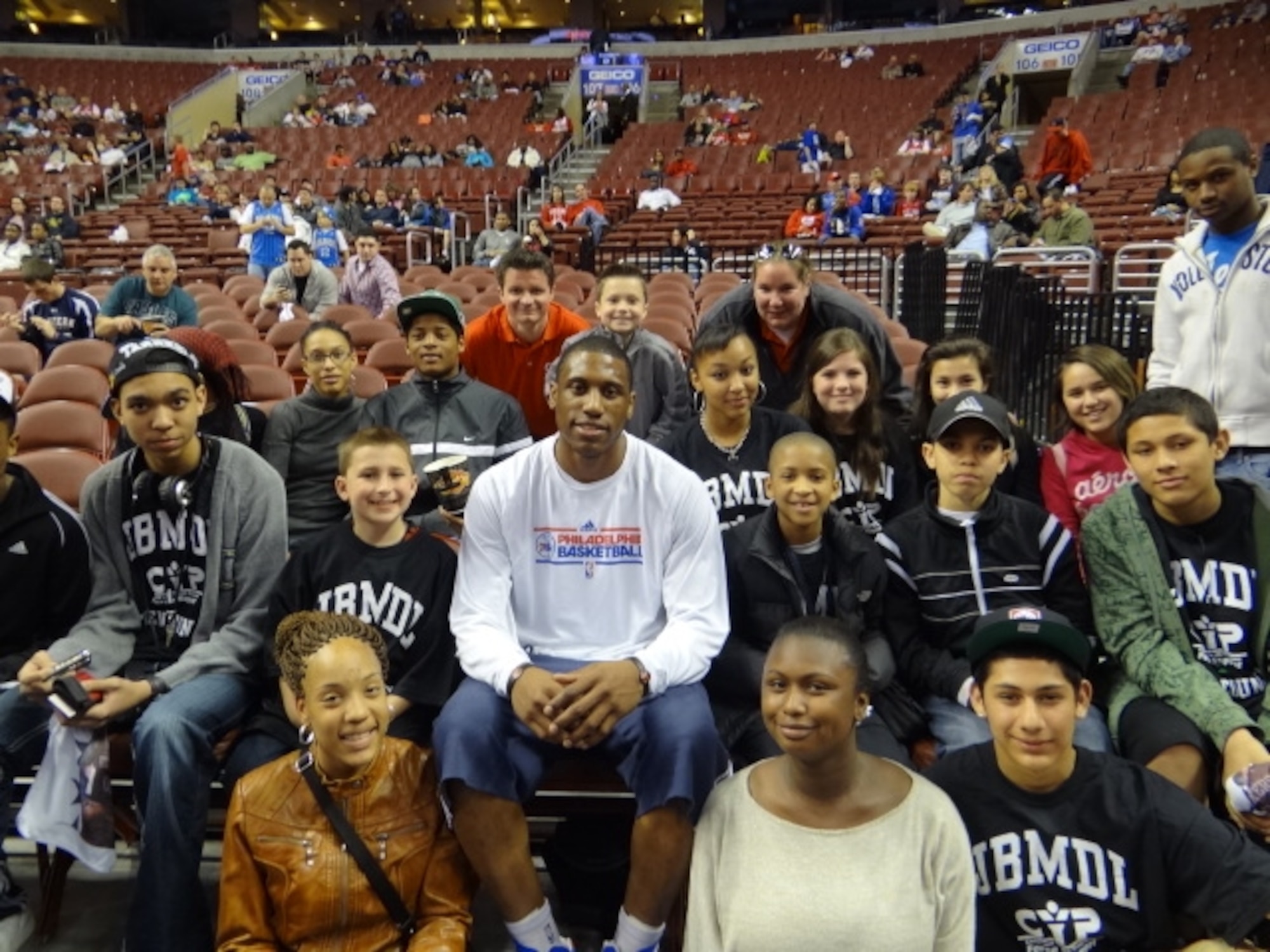 Children of Joint Base McGuire-Dix-Lakehurst service members smile with Philadelphia 76ers Forward Thaddeus Young at a 76ers game April 7. The 20 JB MDL youth in attendance are aged nine to 18 and are members of the JB MDL boys and girls basketball teams and teen council. (U.S. Air Force Courtesy Photo/Released)